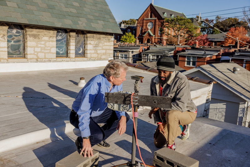 Tyler Cargill (right), a recent PhD graduate of WashU McKelvey Engineering, looks over air monitoring equipment on a roof in south St. Louis with his adviser, Jay Turner, the James McKelvey Professor of Engineering Education. Turner’s lab will collaborate with the city to do similar air monitoring as tornado cleanup continues. (Photo: Whitney Curtis/WashU)